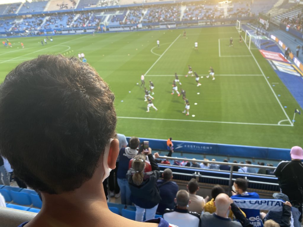 la tête d'un garçon en train de regarder un match de football.