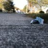 Un masque jetable bleu jeté par terre sur une trottoir