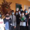 Un groupe de neuf jeunes étudiants avec des masques au visage sont debout côte à côte.