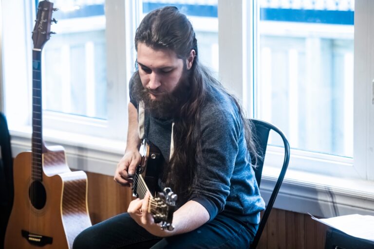 Un homme, Benjamin James, joue de la guitare dans un café à St. John's, Terre-Neuve